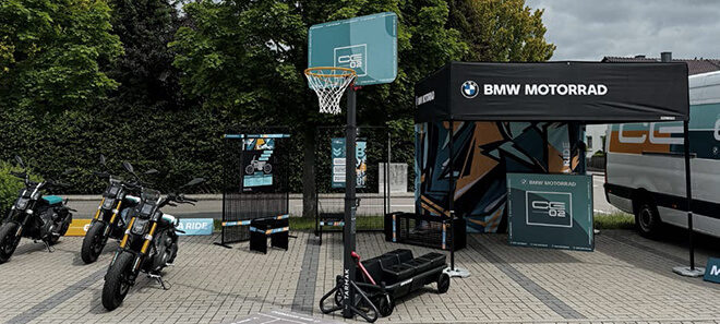 BMW Motorrad Promotion-Stand bzw. BMW CE 02 Playground mit BMW CE 02 E-Motorrädern, Basketballkorb und Infostation im urbanen Design.