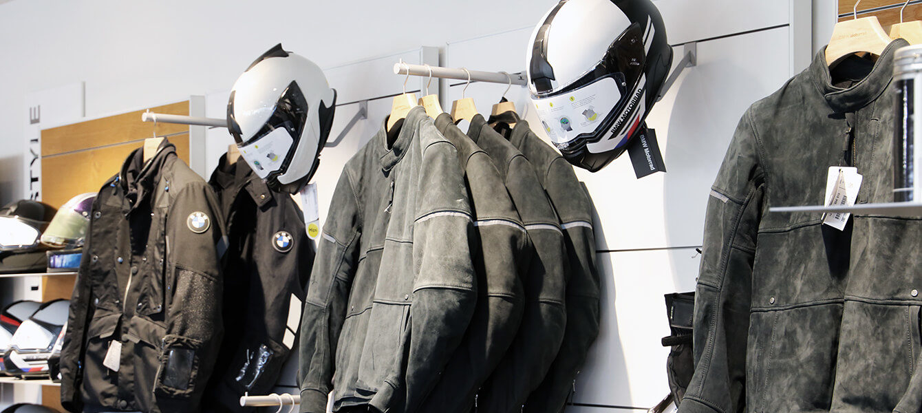 BMW Motorrad Bekleidung mit hochwertigen Lederjacken und Integralhelmen im Showroom.