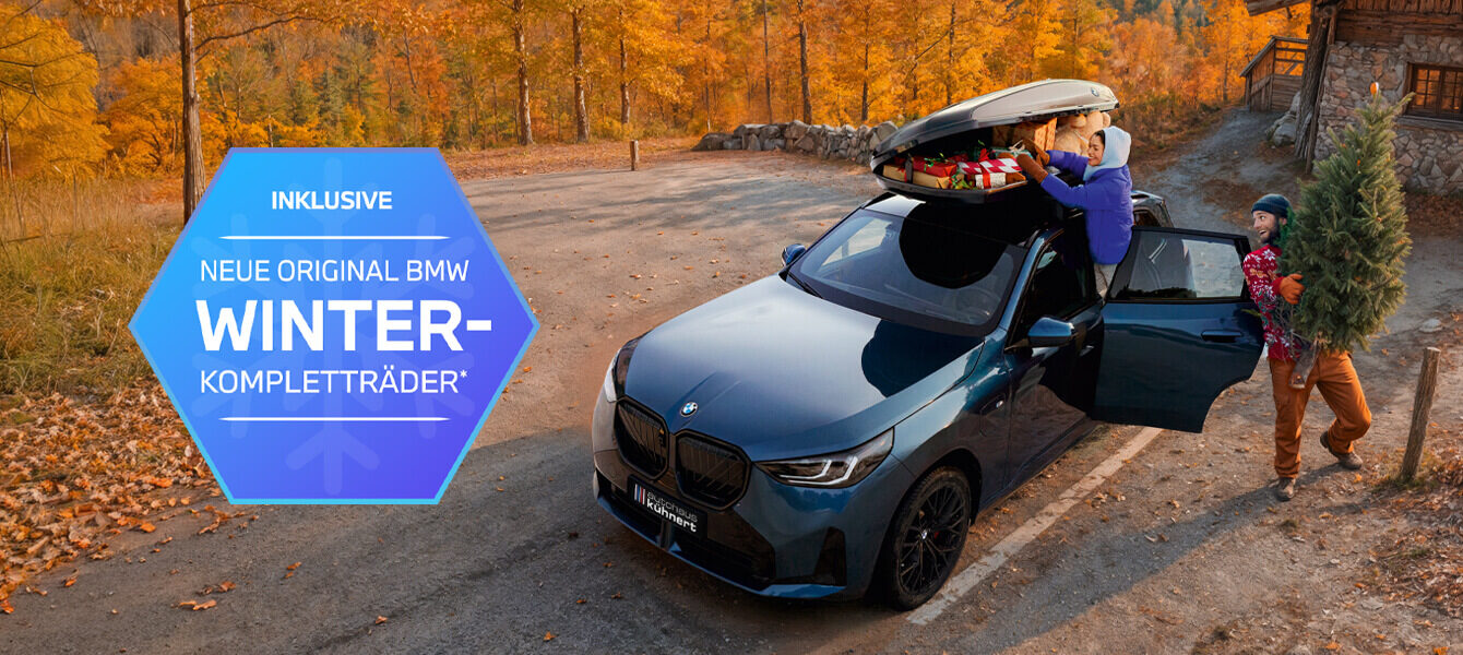 BMW mit Winterkompletträdern vom Autohaus Kühnert vor Berghütte im Herbst, Familie lädt Geschenke und Weihnachtsbaum ein.