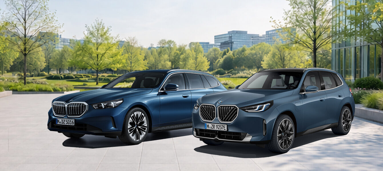 BMW 5er Touring und BMW X3 vor modernem Gebäude im Grünen bei Autohaus Kühnert