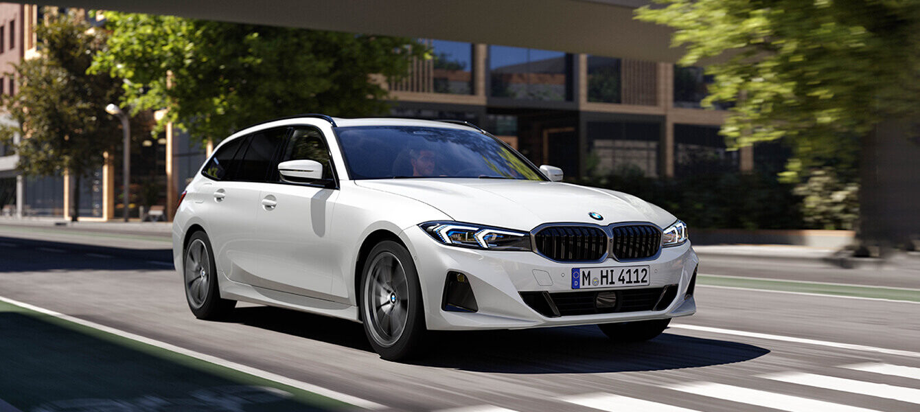 BMW 3er Touring in Weiß auf urbaner Straße – dynamischer Kombi mit modernem Design und effizientem Fahrkomfort bei Autohaus Kühnert.