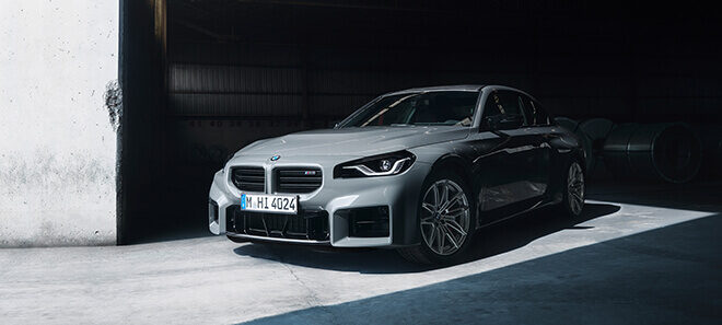 BMW M2 Coupé in Frontansicht in moderner Industriehalle.
