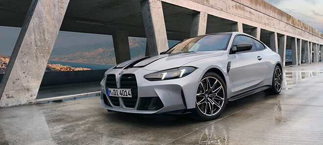 BMW M4 Competition Coupé in Frontansicht auf modernem Parkdeck.