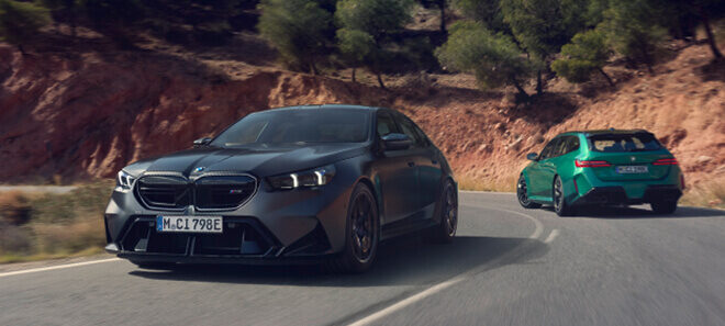BMW M5 Touring und BMW M5 Limousine auf kurviger Bergstraße.
