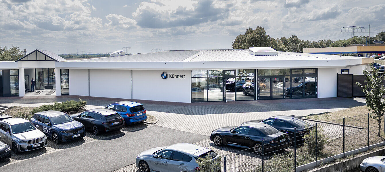 Autohaus Kühnert Standort Altenburg mit modernem BMW Autohaus, Ausstellungsfläche und geparkten BMW Fahrzeugen.