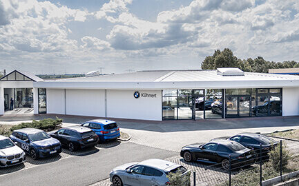 Autohaus Kühnert Standort Altenburg mit modernem BMW Autohaus, Ausstellungsfläche und geparkten BMW Fahrzeugen.