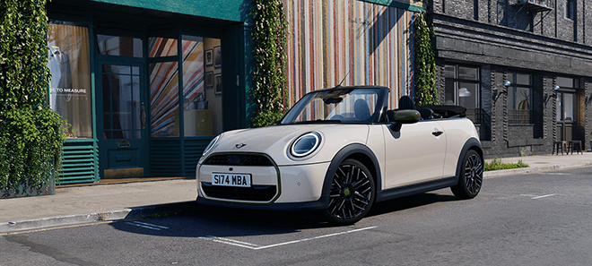 MINI Cooper Cabrio Paul Smith Edition in Weiß mit geöffnetem Verdeck und grünen Akzenten in urbaner Umgebung