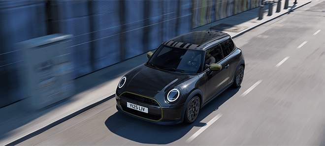 MINI Cooper Paul Smith Edition in schwarz mit grünen Designakzenten bei der Fahrt durch die Stadt