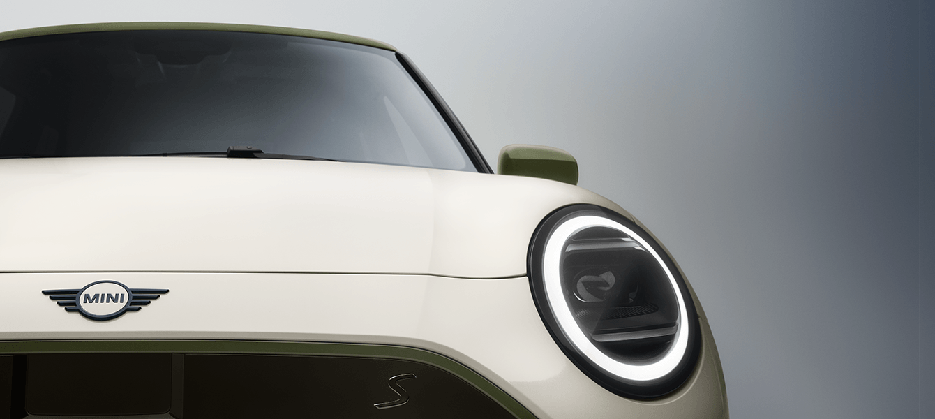 Frontdetail der MINI Paul Smith Edition in Weiß mit grünem Außenspiegel, MINI Logo und LED-Scheinwerfer